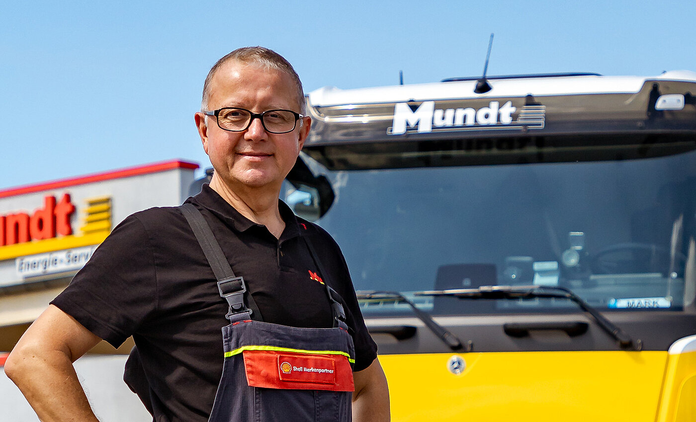 Ein lächelnder Mann steht vor einem LKW