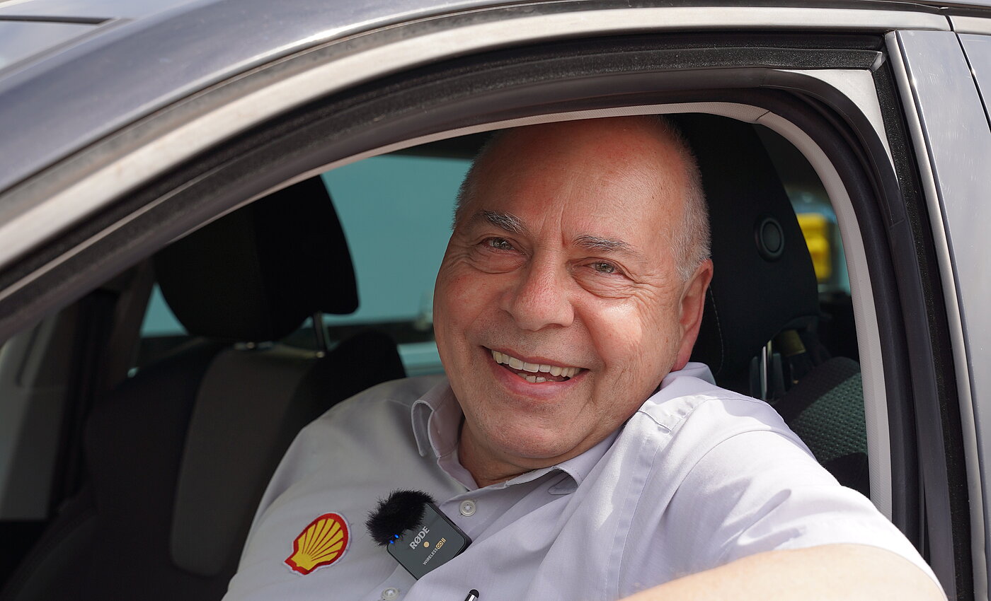 Ein lächelnder Mann, der aus dem Autofenster guckt